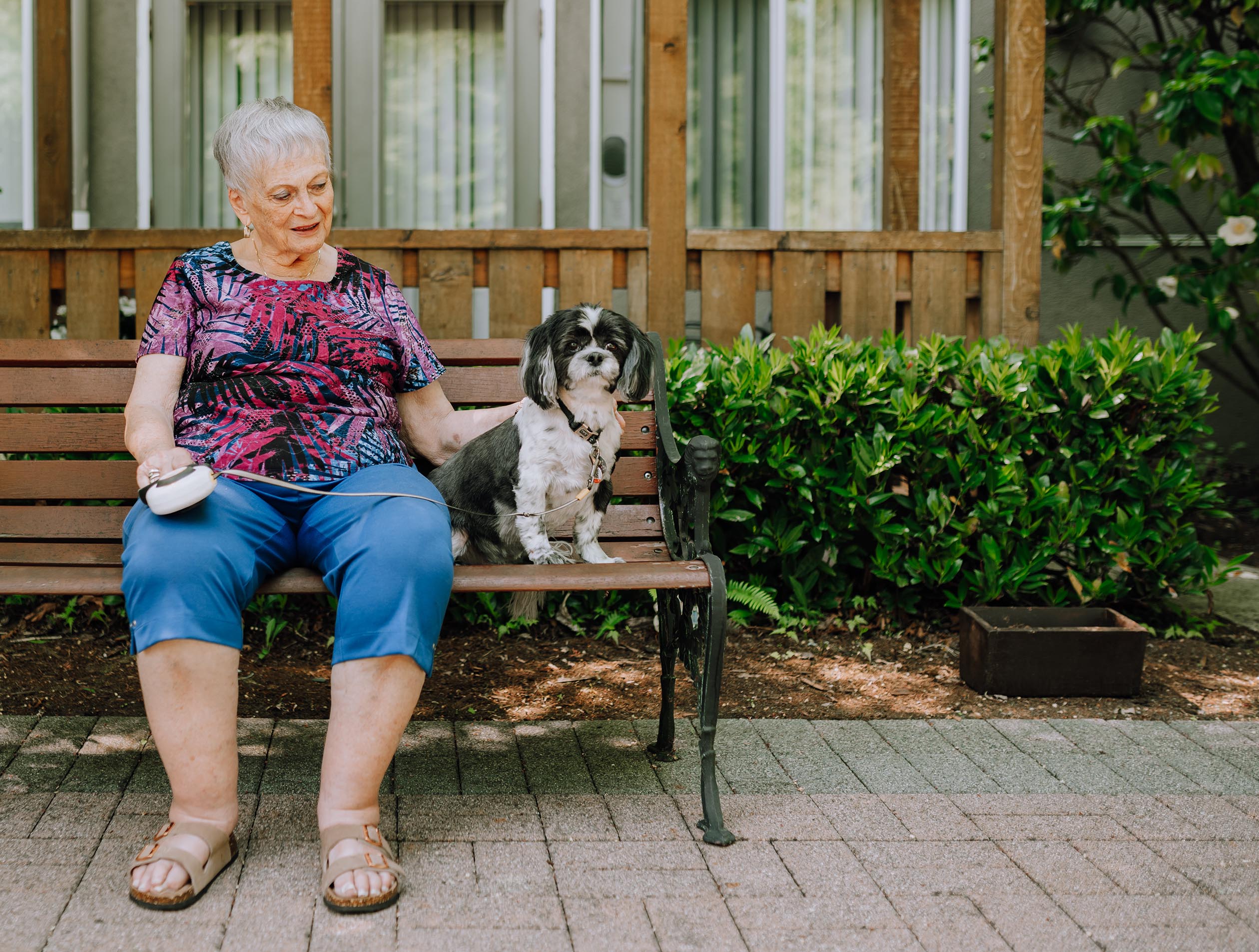 Senior woman sitting with her dog outside her Nanaimo retirement home